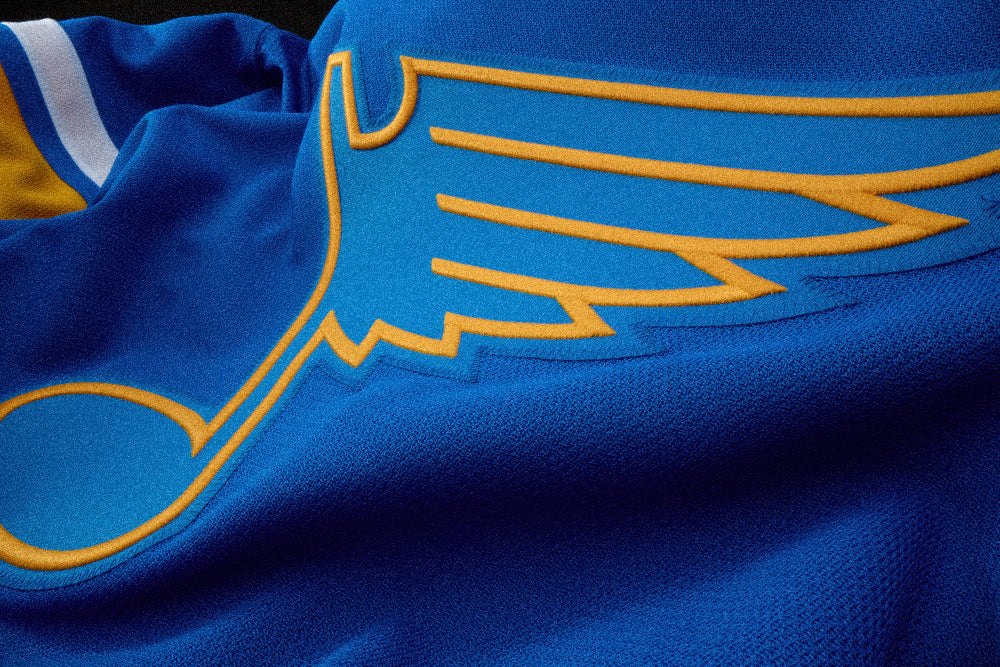 Close-up of a blue sports jersey with a yellow logo
