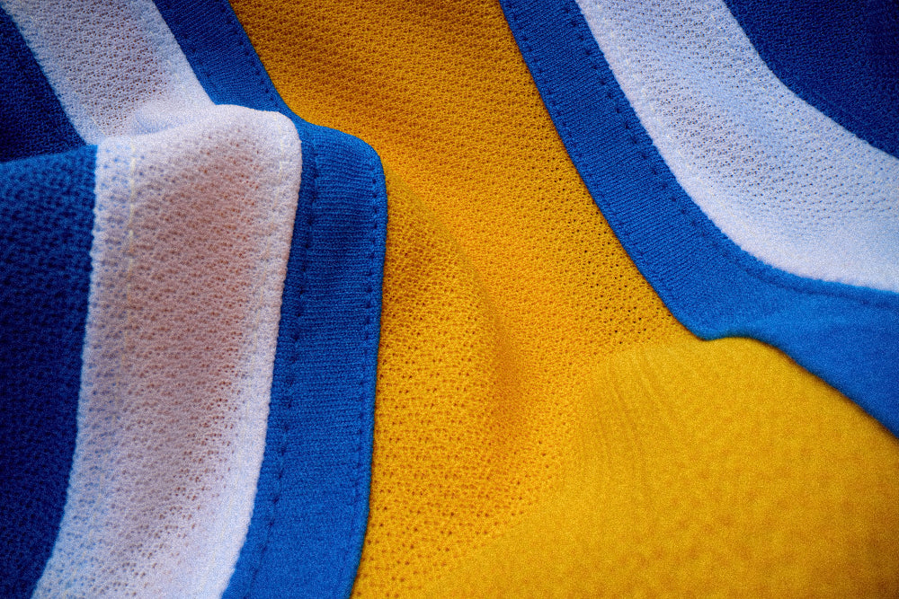 Close-up of a textured fabric with blue, white, and yellow colors.
